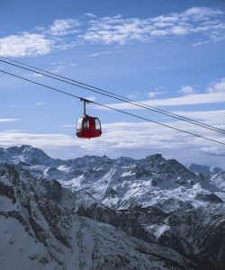 A vertical shot of a cabin of the ropeway over the mountains